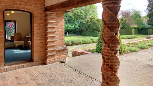 View into a small room overlooking a garden with an elevated terrace to the side